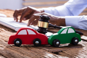 Who-Is-the-Best-Auto-Accident-Lawyer-in-Houston-TX-two-toy-cars-carashed-on-a-des
